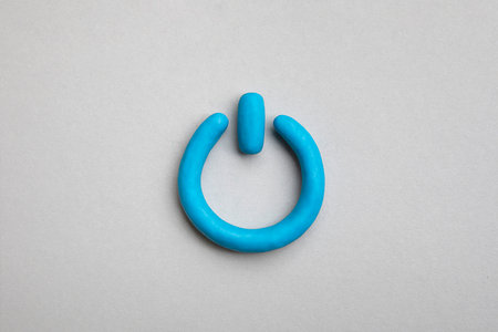 3d plasticine blue start icon on yellow background. Power on off, switch or start and stop button concept.の写真素材