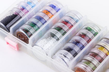 Glass seed beads storage system on white background closeup. Hobby, handmade, fine arts. Selective focus.の写真素材