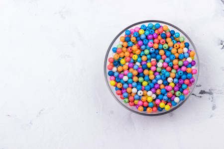 Assorted bead mix on grey background. Selective focus. Top view. Space for text.