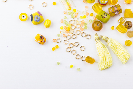 Yellow and lime glass bead mix on white background. Selective focus. Top view.の写真素材