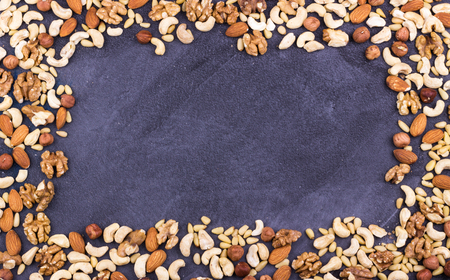 Assorted nuts in a frame laid out on a grey background. Space for text. Selective focus.の写真素材