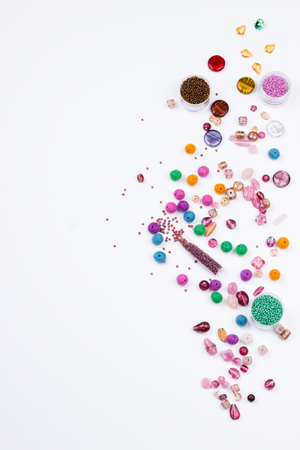 Bead mix. Glass, seed beads and felted beads for jewelrymaking on white background. Hobby, handmade, fine arts. Top view.の写真素材