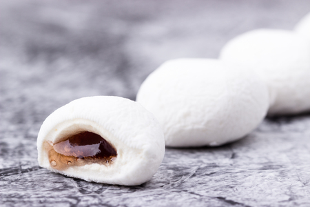 Mochi Japanese dessert with grape flavor closeup on grey background. Selective focus.の写真素材