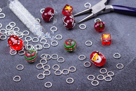 Christmas santa glass beads, crystal seedbeads,metal rings for winter handmade on blue background. Closeup. Selective focus.の写真素材