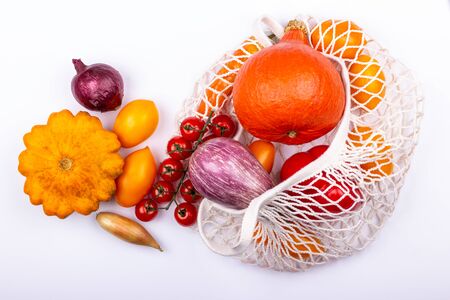 Vegetables in eco shopping bag on white background. Plastic free, reduce. Top view. Selective focus.の写真素材