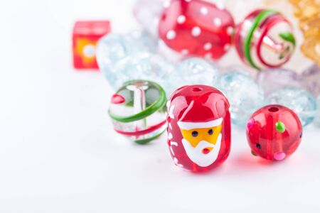 Colorful assortment of glass beads for beadwork. Christmas glass beads closeup on white background. Selective focus.の写真素材
