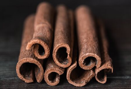 Cinnamon sticks closeup on wooden background. Low-key. Rustic. Selective focus.の写真素材