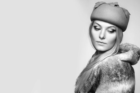 close portrait of beautiful blond woman in retro vintage style, hat and fur. copy space. black and white.の写真素材