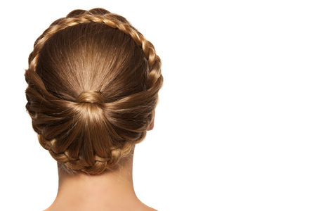 portrait of a beautiful young blonde woman on a light background with hairdo on her head. copy space.の写真素材