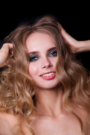 Beauty Fashion Model Woman , portrait,  hairstyle with creative hair-dress, curls waves. Concept Girl face with perfect skin in dark Backgroundの写真素材