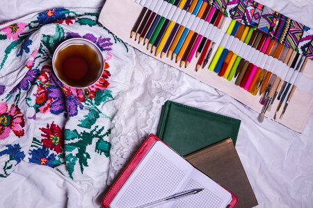 Top view of paint, a blank sheet of paper, cup of tea, markers.の写真素材