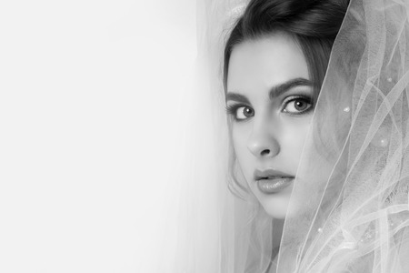 Beautiful young woman bride with wedding hairstyle. Portrait on a light background in pastel colors. Cute concept of commercial fashion photography. copy space. Black and white .の写真素材