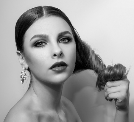 Fashionable portrait of a girl model. Fashion, accessories, evening  wet effect makeup. Glamour  style lady, nude shoulders. Black and white, monochrome photoの写真素材