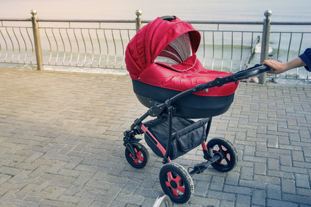 A stroller strolls in the seaside. toned photo