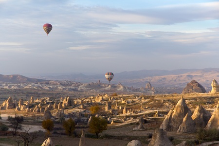 CAPPADOCIA, TURKEY - NOVEMBER 23: Tourists Enjoy the Unique Valleys and Fairy Chimneys While Floating Over Cappadocia at Sunset in Colorful Hot Air Ballons On November 23, 2010 in Cappadocia, Turkeyのeditorial素材