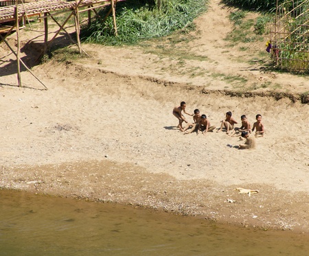 LUANG PRABANG, LAOS- FEBRUARY 19: A Group of Young Local Boys Play on the Banks of the Nam Khan River on February 19, 2011 in Luang Prabang, Laos のeditorial素材
