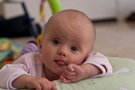 Caucasian baby girl playing on her colorful playmat.の写真素材