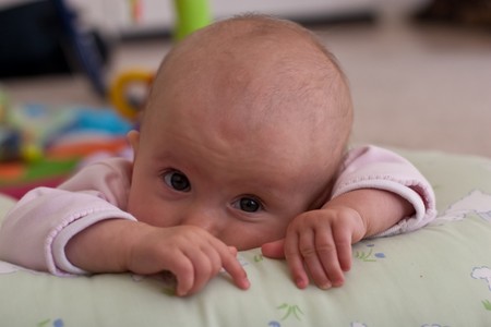 Caucasian baby girl playing on her colorful playmat.の写真素材