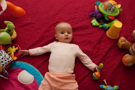 Little Caucasian baby girl playing on a floor.の写真素材