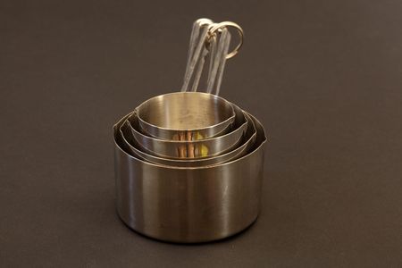 Measuring cup is a kitchen utensil used primarily to measure the volume of liquid or powder-form cooking ingredients such as water, milk, juice, flour, and sugarの写真素材