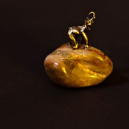 Small metal statue of elephant on a stone.の写真素材