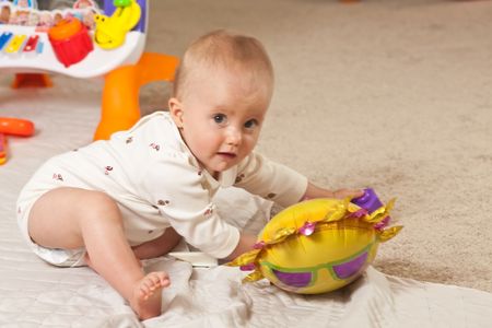 Caucasian baby girl playing on a floor.の写真素材