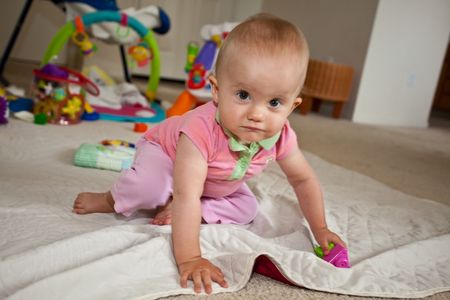 Caucasian baby girl playing on a floor.の写真素材