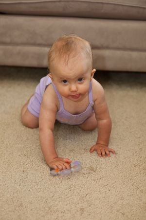 Cute Caucasian baby girl playing on a floor.の写真素材