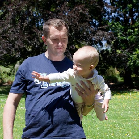 Father holding his dauther in a park.の写真素材