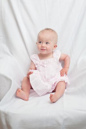 Cute little caucasian baby girl wearing pink dress on a white backgroundの写真素材