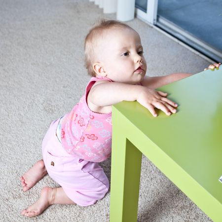 Cute Caucasian baby girl playing on a floor.の写真素材