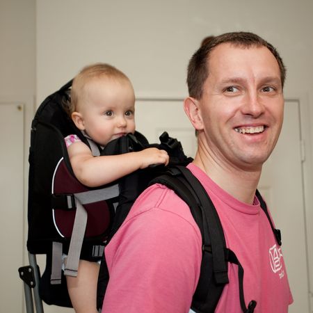 Child carrier is a device used to carry an infant or small child on the body of an adult.の写真素材