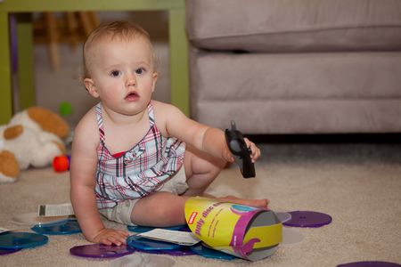 Caucasian baby girl playing on a floor.の写真素材