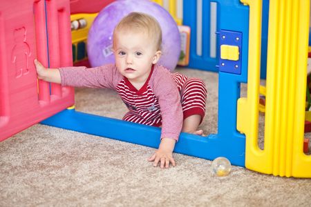 Cute Caucasian baby girl playing on a floor.の写真素材