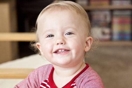 Cute Caucasian baby girl playing on a floor.