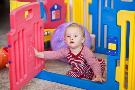 Cute Caucasian baby girl playing on a floor.の写真素材