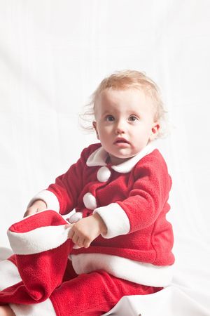 Cute caucasian baby girl wearing Santa suit on white background.の写真素材