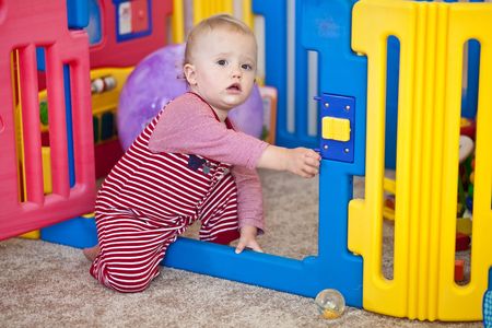 Cute Caucasian baby girl playing on a floor.の写真素材