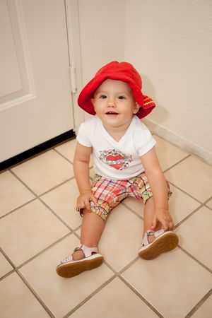 Cute Caucasian baby girl playing on a floor.の写真素材