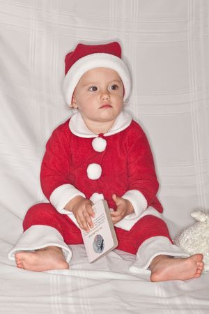 Cute caucasian baby girl wearing Santa suit on white background.の写真素材