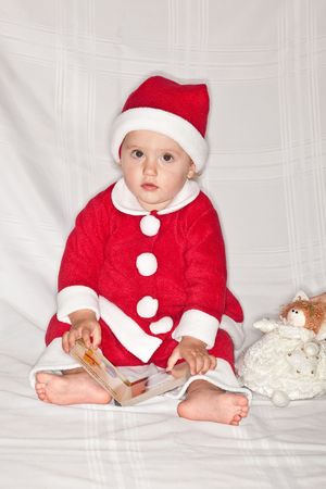Cute caucasian baby girl wearing Santa suit on white background.の写真素材