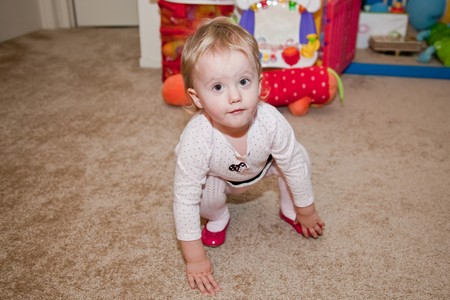 Caucasian baby girl playing on a floor.の写真素材