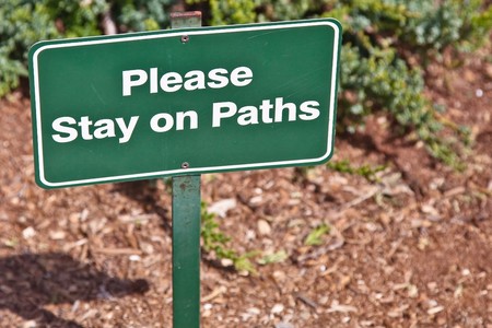 Metal sign warning about staying on the path.の写真素材