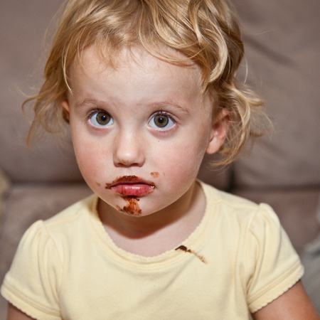 Cute little European toddler girl enjoying chocolate cookie.の写真素材