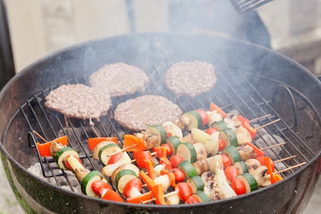 Food cooking on a charcoal grill in a park.の写真素材