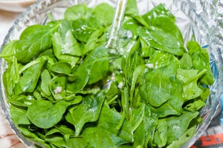 Spinach in a large salad bowl on a party table.の写真素材