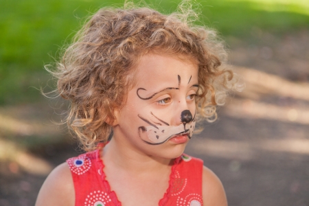 Having fun with face paited during party in park.