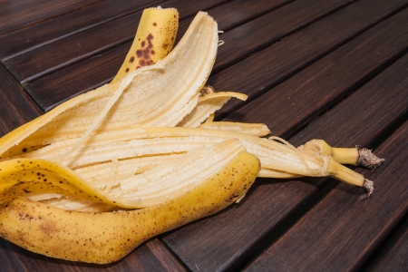 Banana peel on dark brown wooden table.の写真素材