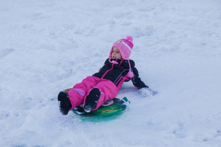 Having fun sledding down hill in the snow.の写真素材