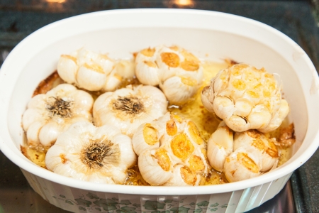 Garlic becomes sweet, mellow, and nutty when roasted. Squeeze the flesh out of the cloves and spread on bread for a great appetizer or side dish.の写真素材